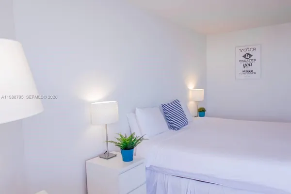 a bedroom with a bed and a potted plant