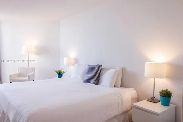 a bedroom with a bed and a lamp