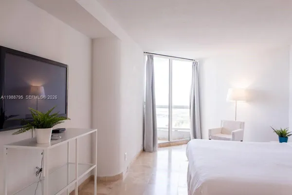 a bedroom with a large bed and a window
