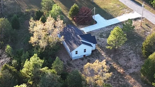 a aerial view of a house with a yard and flowers