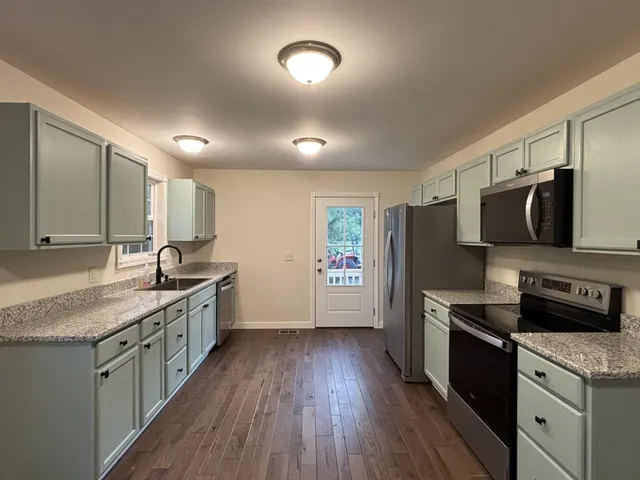 a kitchen with stainless steel appliances granite countertop a sink stove and refrigerator