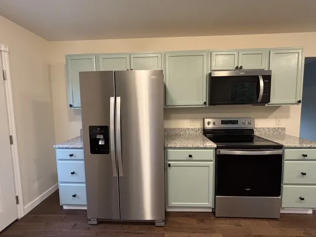 a kitchen with cabinets stainless steel appliances and a counter space