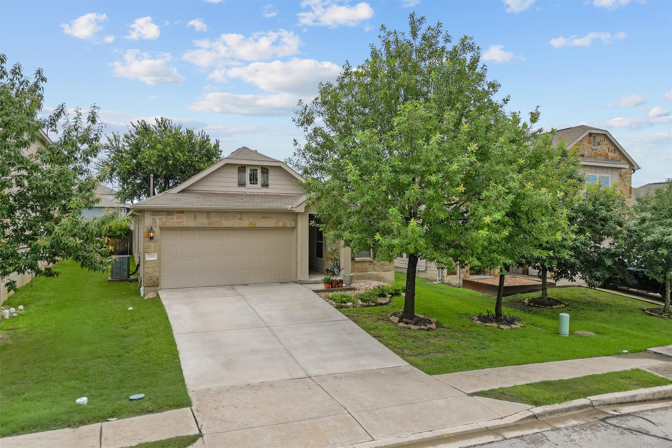 10413 Crescendo Lane Austin, TX 78747 - Photo 29 of 32 Mature trees and lush lawns enhance the curb appeal of this charming residence.