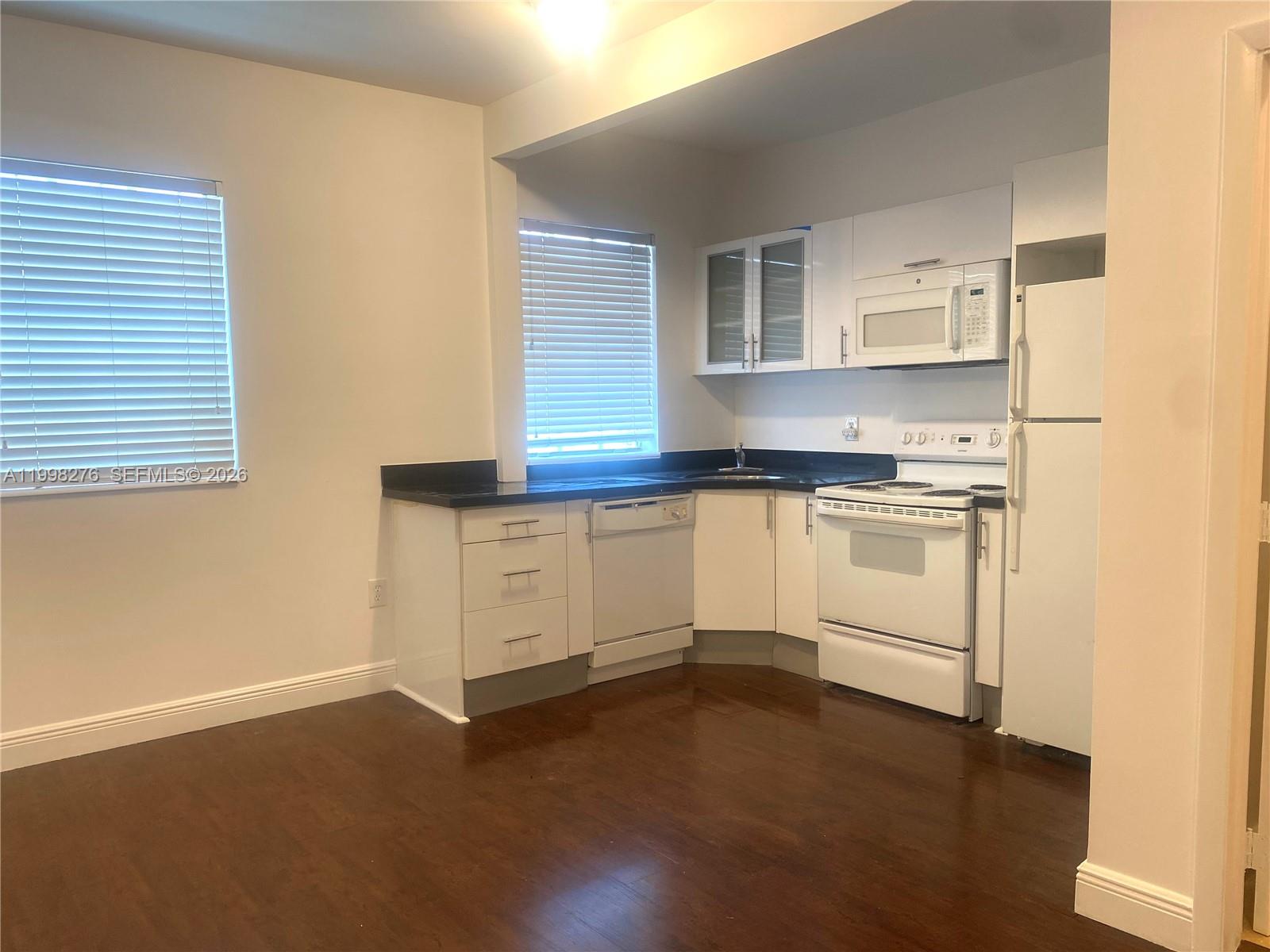 577 Northeast 62nd Street, Unit 8 Miami, FL 33138 - Photo 6 of 21 a kitchen with granite countertop white cabinets and white appliances