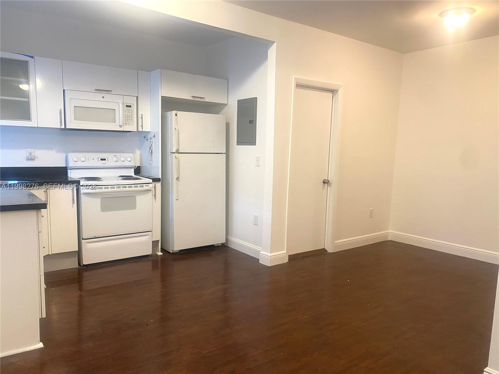 577 Northeast 62nd Street, Unit 8 Miami, FL 33138 - Photo 7 of 21 a kitchen with a refrigerator stove and white cabinets