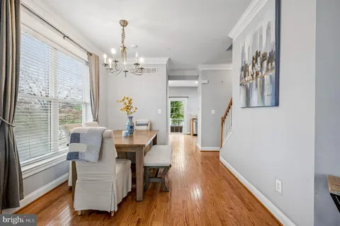 a dining room with furniture a chandelier and wooden floor