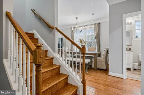 a view of staircase with lots of frames on wall and wooden floor