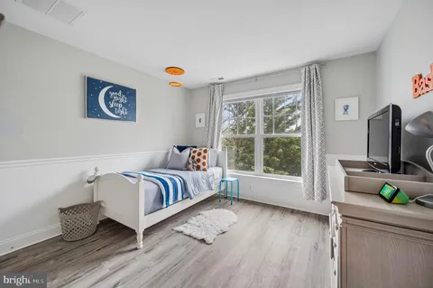 a bedroom with a bed and a flat tv screen on the dresser