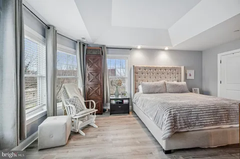 a bedroom with a bed and large windows