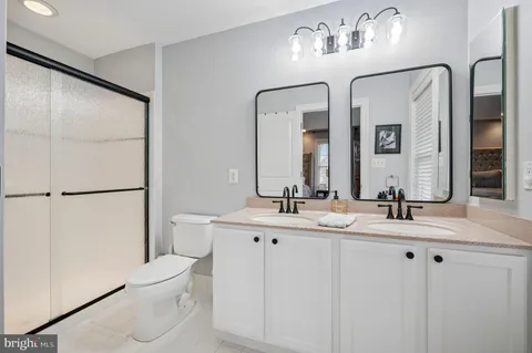 a bathroom with a double vanity sink mirror and toilet