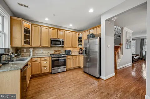 a kitchen with stainless steel appliances granite countertop a refrigerator stove and oven