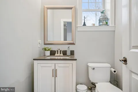 a bathroom with a granite countertop toilet sink and mirror