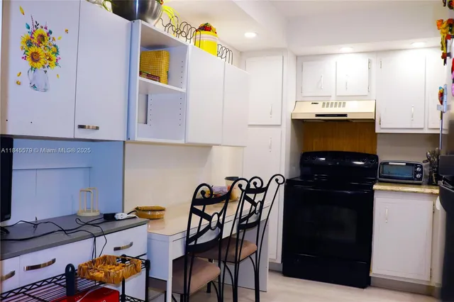 a kitchen with a refrigerator and a stove top oven