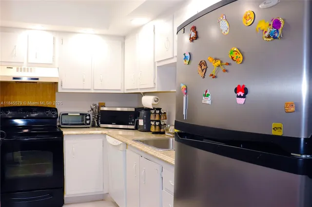 a kitchen with stainless steel appliances granite countertop a refrigerator and a stove