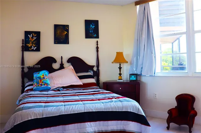 a bedroom with a bed a flat tv screen and a desk