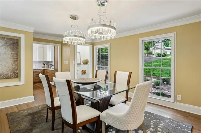 a dining room with furniture a chandelier and wooden floor