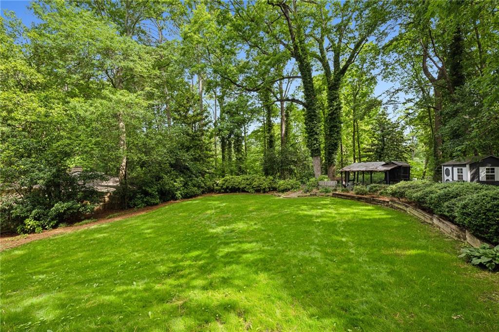 1130 Angelo Court Northeast Atlanta, GA 30319 - Photo 2 of 38 a view of a garden with a bench and trees