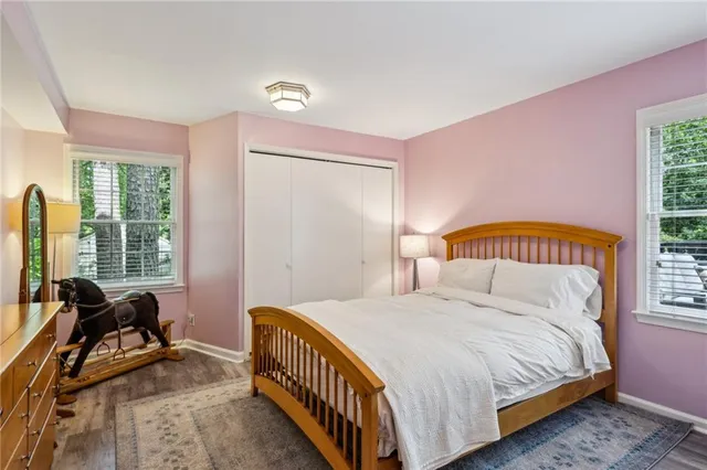 a bedroom with a bed a table and a dresser next to a window