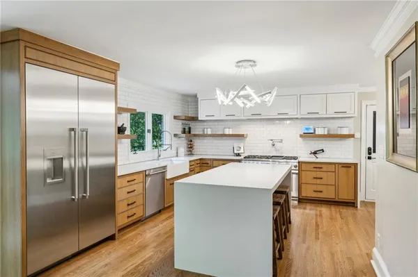 a kitchen with stainless steel appliances a refrigerator sink and cabinets