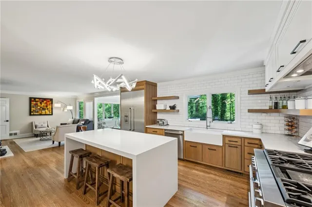 a large kitchen with a stove a sink dishwasher and a stove with wooden floor