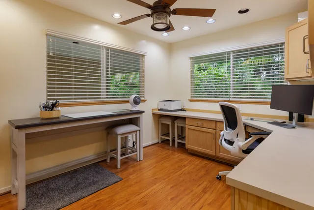 a view of a workspace with furniture and a window