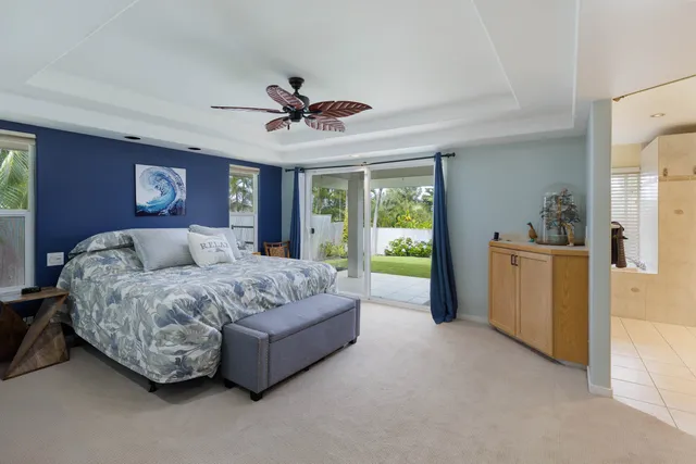 a spacious bedroom with a bed couch and a ceiling fan