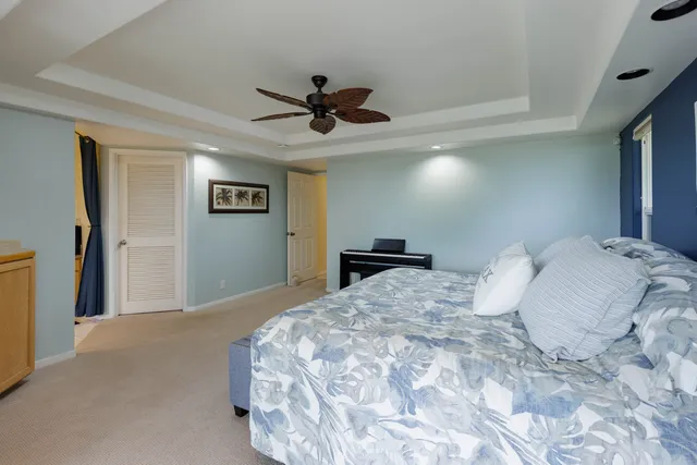 a bedroom with a large bed and a chandelier