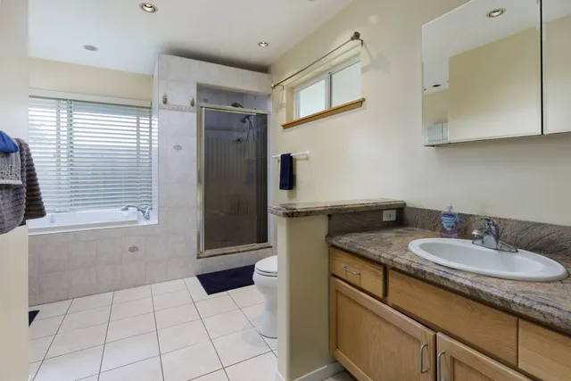 a bathroom with a granite countertop sink a mirror and a bathtub