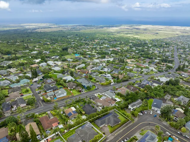 an aerial view of residential houses with outdoor space and trees