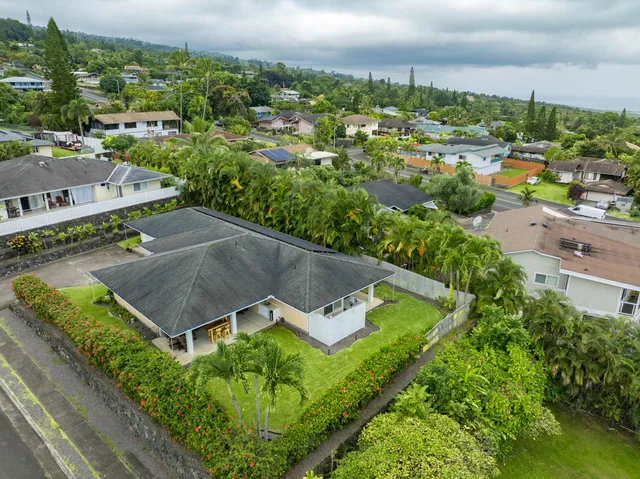 an aerial view of a house with yard and green space
