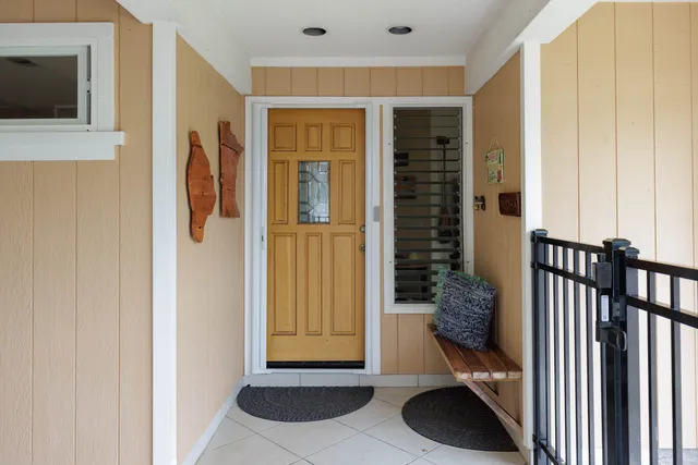 a view of a hallway with wooden floor and a bathroom