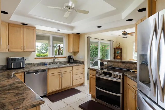 a kitchen with stainless steel appliances granite countertop a stove a sink dishwasher a refrigerator and cabinets with wooden floor