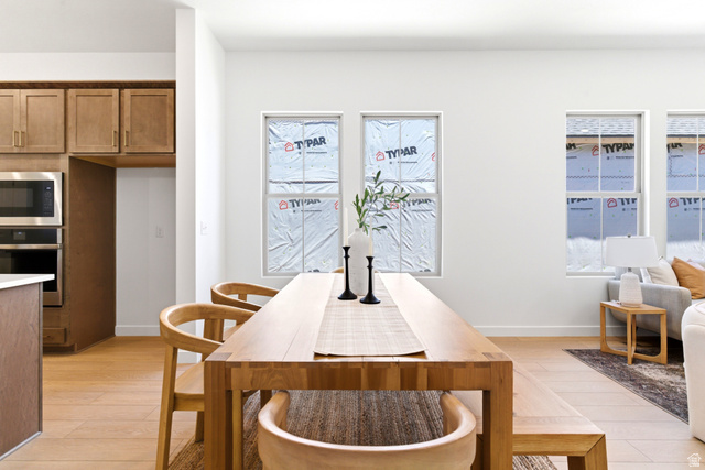 7243 West Terraine Road West Jordan, UT 84081 - Photo 5 of 31 Open-concept living area featuring light wood-finish flooring, white walls, and multiple windows