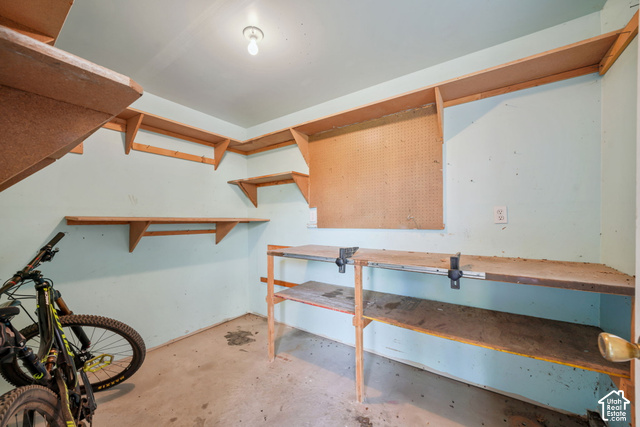 380 Luzern Road Midway, UT 84049 - Photo 18 of 41 Built-in shelving, pegboard, concrete flooring, and a workbench with integrated vises connected to garage