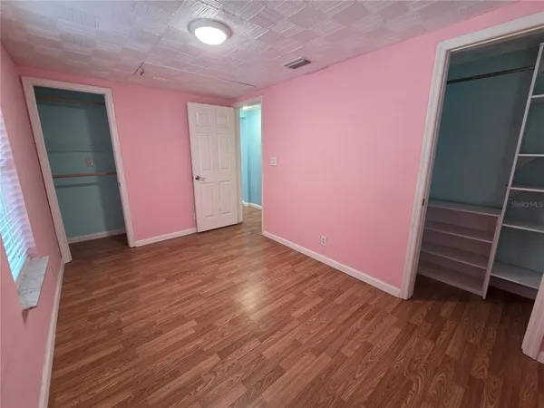 an empty room with wooden floor and window