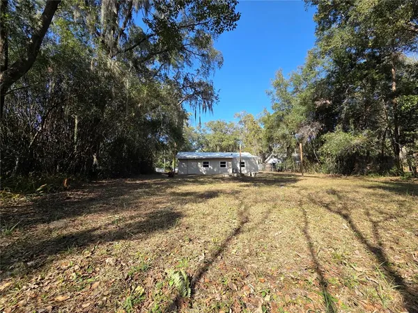 a view of yard with swimming pool and trees
