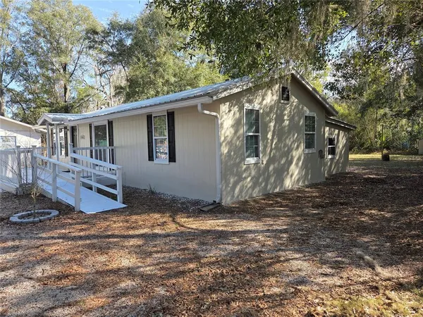a view of a house with backyard and trees