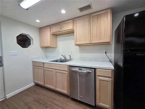 a kitchen with granite countertop a sink stainless steel appliances and cabinets