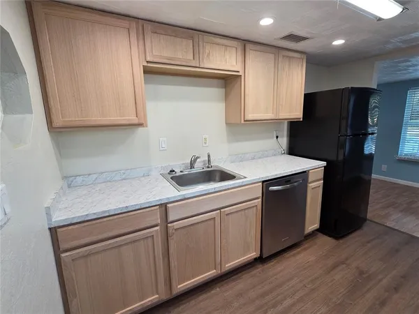 a kitchen with stainless steel appliances granite countertop a sink a stove a refrigerator and cabinets