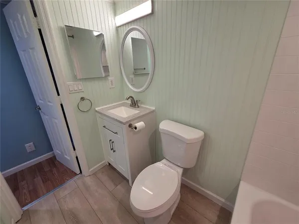 a bathroom with a toilet a sink and a mirror