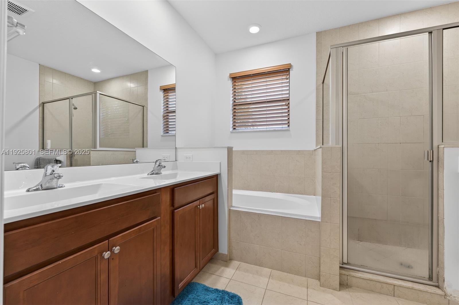 6978 Broadland Way Pompano Beach, FL 33073 - Photo 35 of 56 a bathroom with a double vanity sink a mirror and a shower
