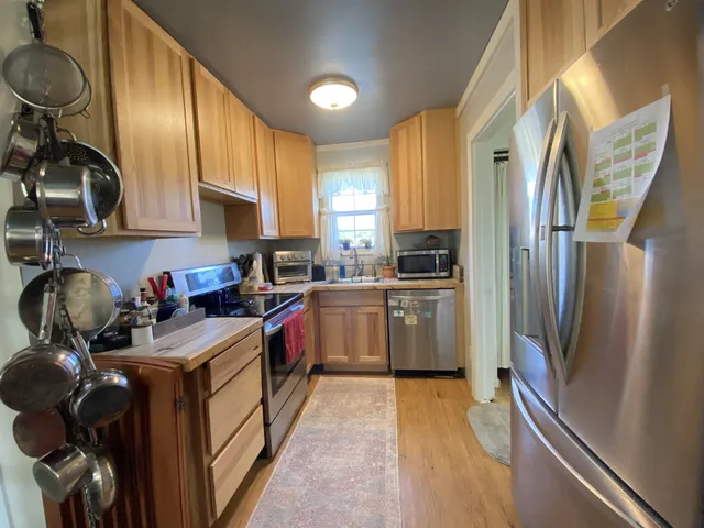 a kitchen with stainless steel appliances granite countertop a stove a sink and a microwave