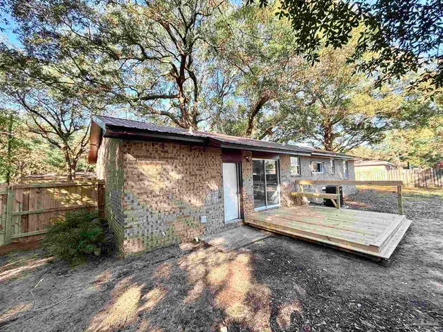 a view of backyard with large trees and barbeque oven