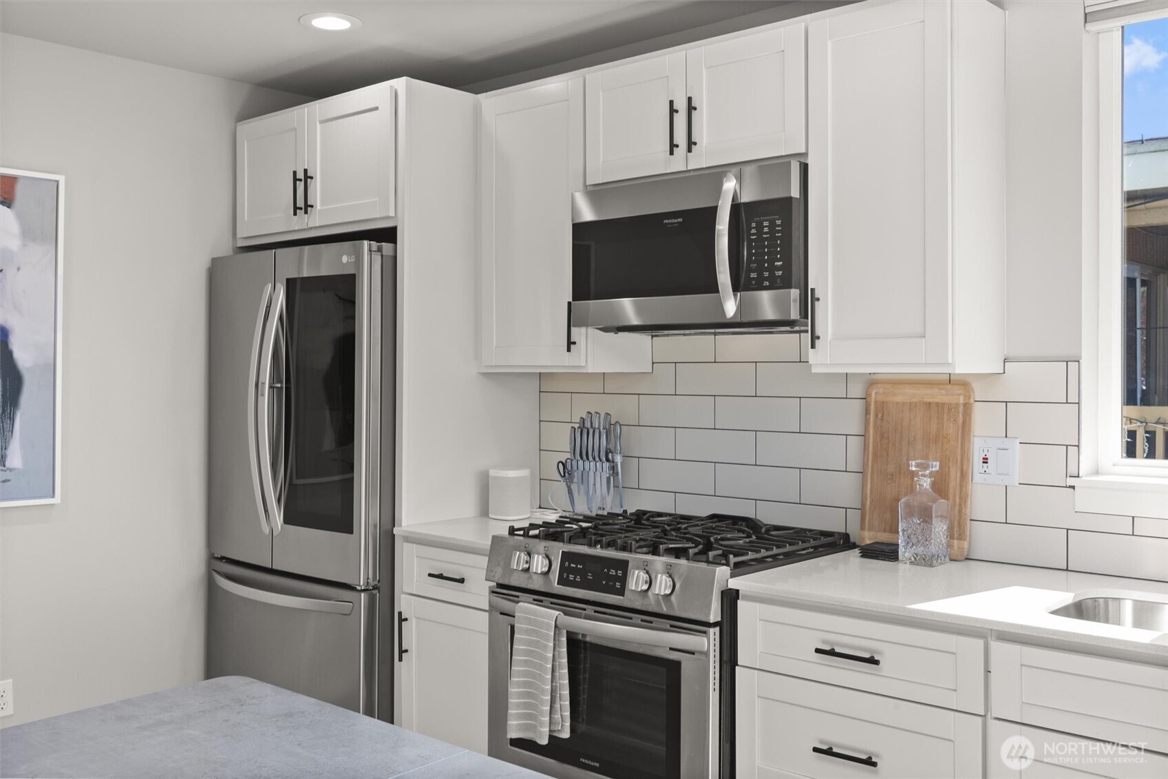3638 36th Avenue South, Unit D Seattle, WA 98144 - Photo 15 of 21 a kitchen with stainless steel appliances white cabinets and a stove top oven