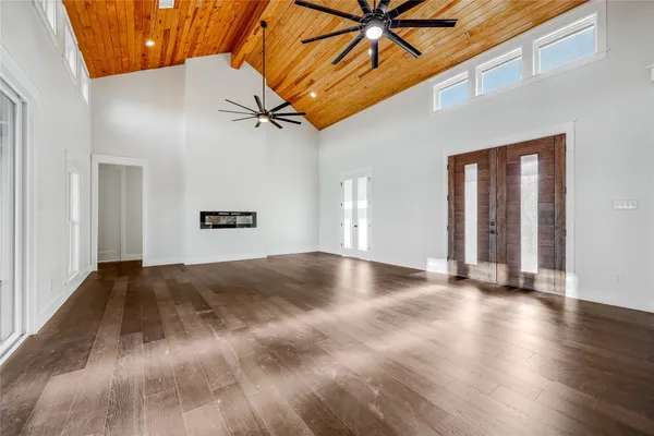 a view of an empty room with kitchen appliances and a ceiling fan