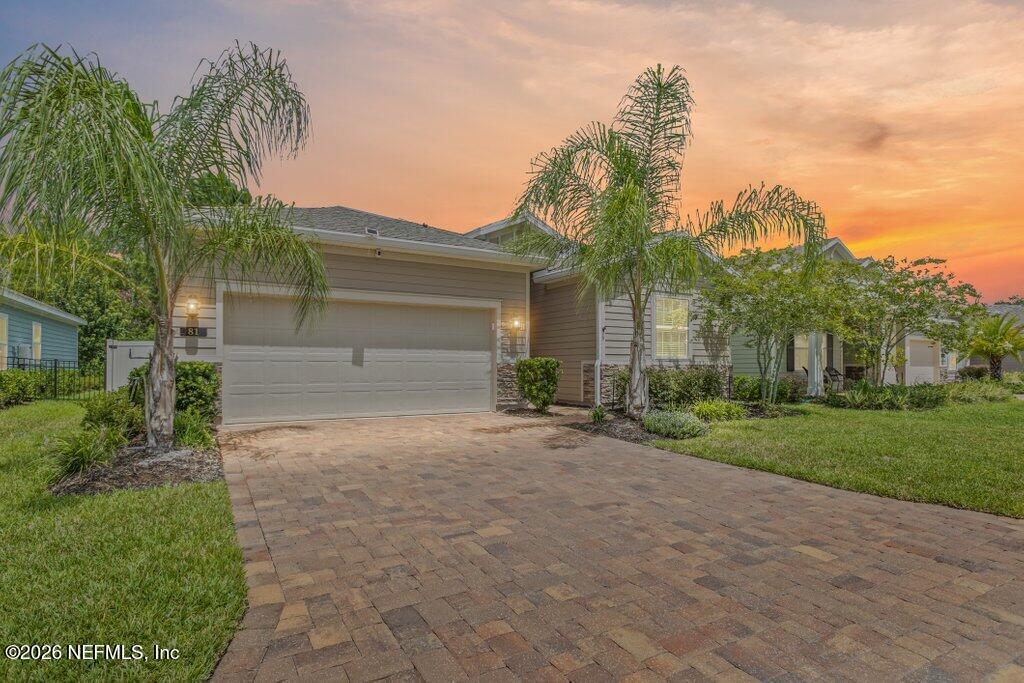 a front view of a house with a yard and a garage
