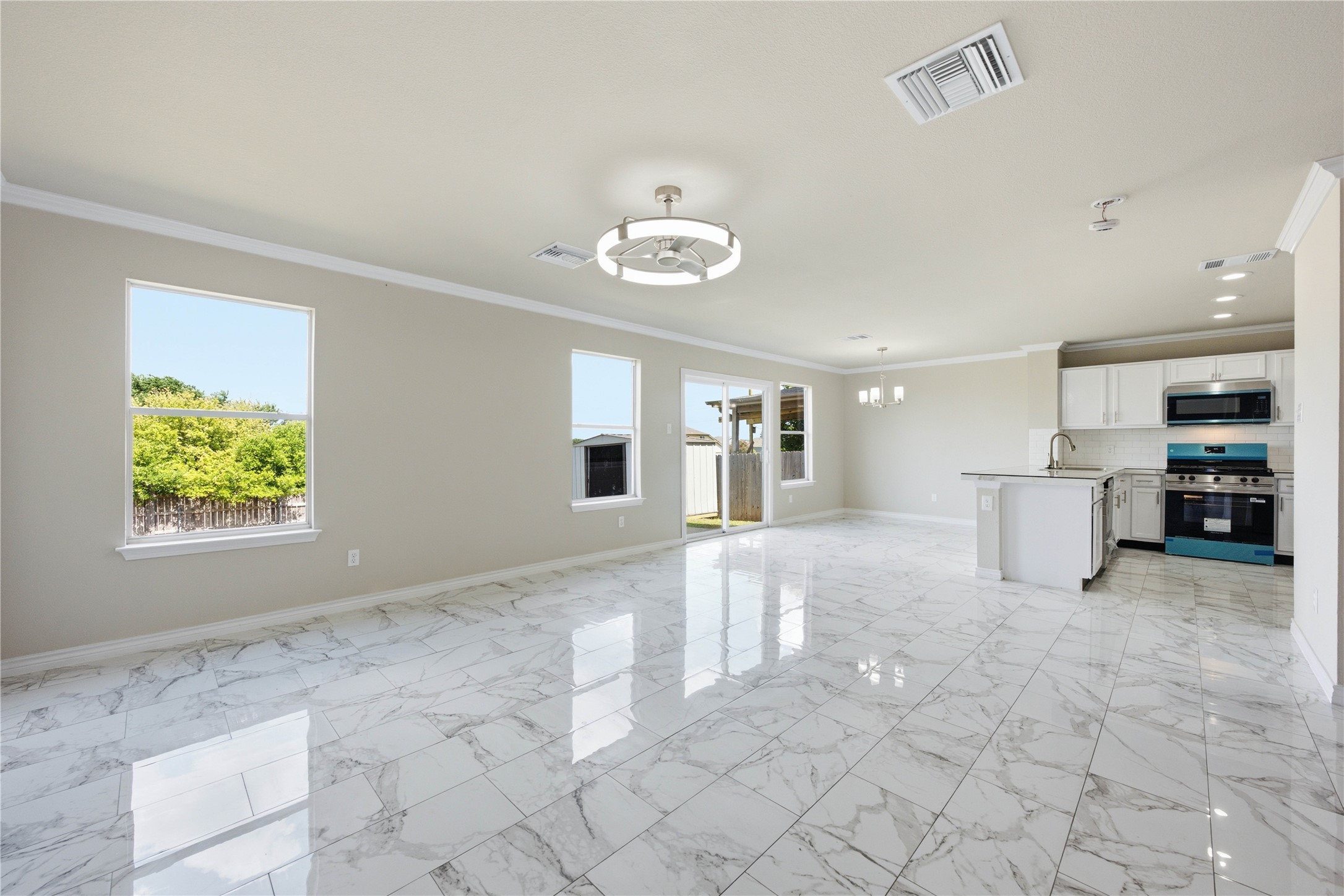 6917 Panda Royle Drive Del Valle, TX 78617 - Photo 4 of 23 A luminous living space features gleaming tile flooring and a sleek, contemporary kitchen.