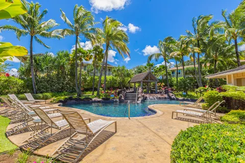 a view of a backyard with plants and swimming pool