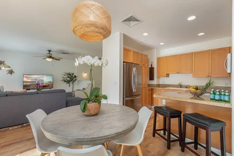 a view of a dining room with furniture a potted plant and a chandelier