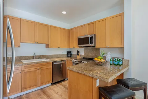 a kitchen with stainless steel appliances granite countertop a sink stove microwave and refrigerator